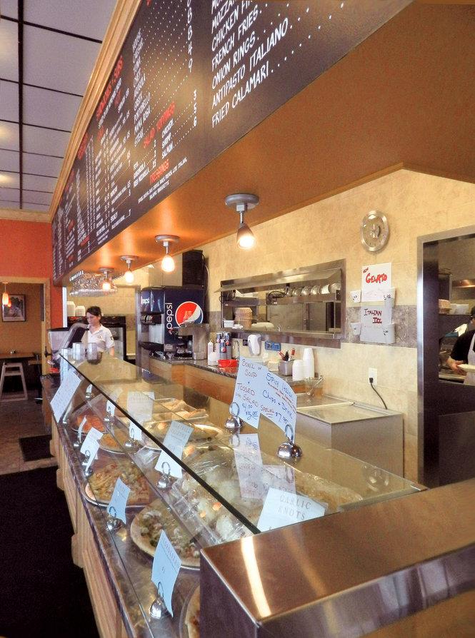 Front counter, menu wall, and display case inside Palumbo Pizza Hampden Township